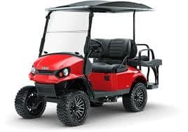 A red Yamaha golf cart with black seats, a roof, a windshield, and rugged wheels on a white background.